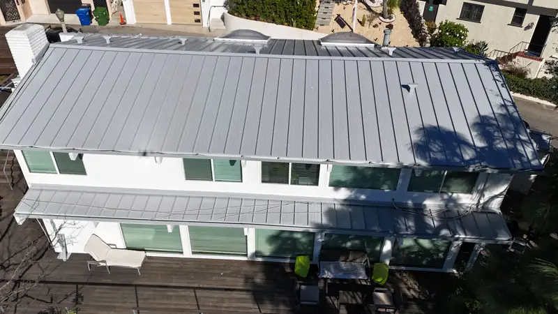 Finished gray standing seam metal roof on a two-story Los Angeles house