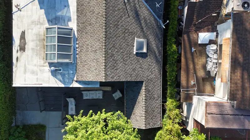 Old composition shingle roof with skylights, seen from above before any work starts